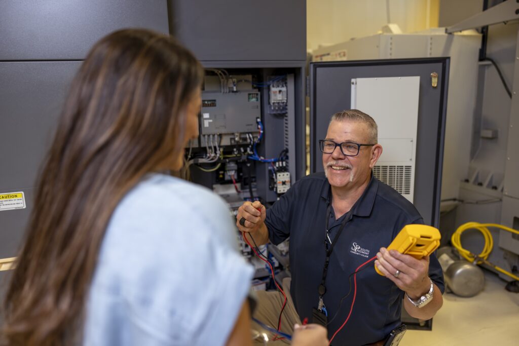 Billy Spencer demonstrating how to handle a equipment in front of a student