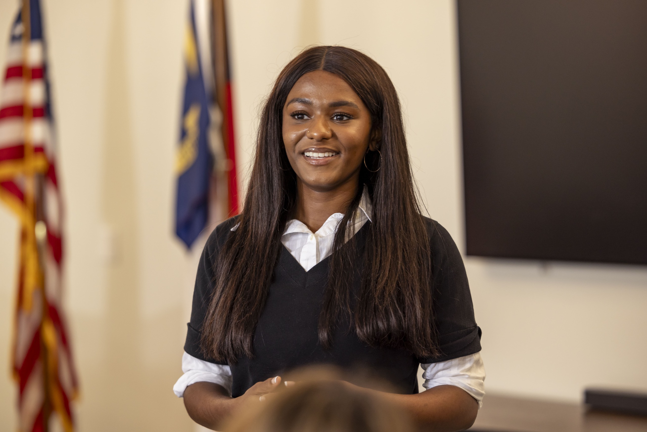 Female student standing at the front of a classroom.